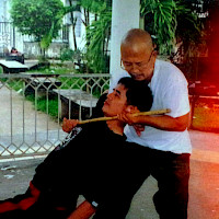 Master Cris demonstrating empty hand defense against stick with Guro Totong.
