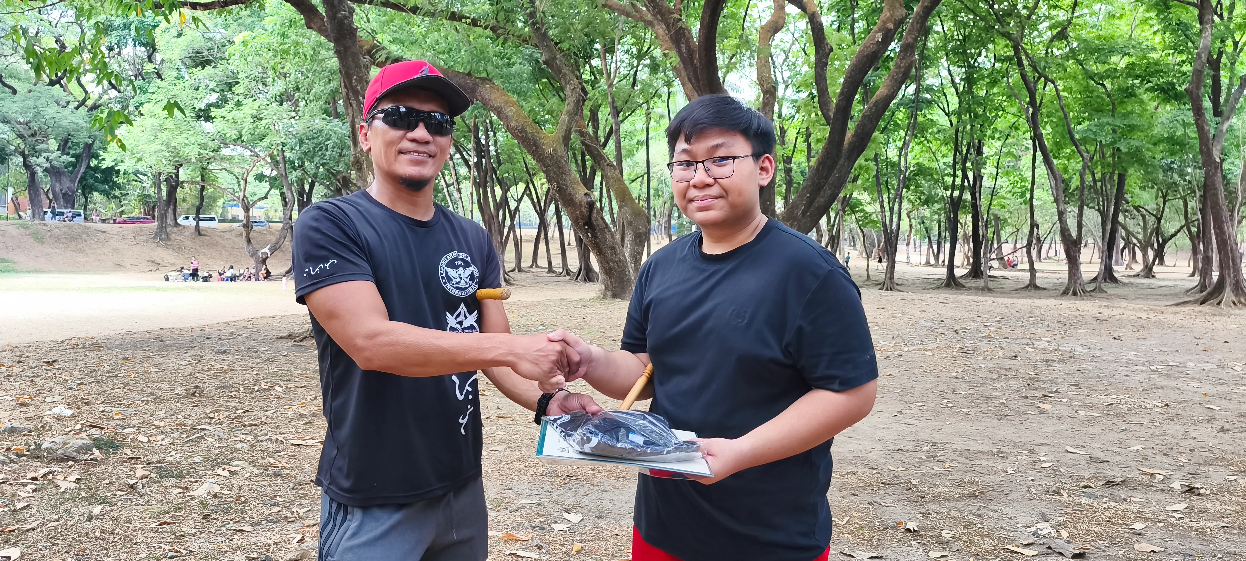 Hector Muzones (R) receiving his official uniform and certificate of promotion to the rank of Luntian from Lapunti Karilyon Chief Instructor, Senior Master Buboy Ador.