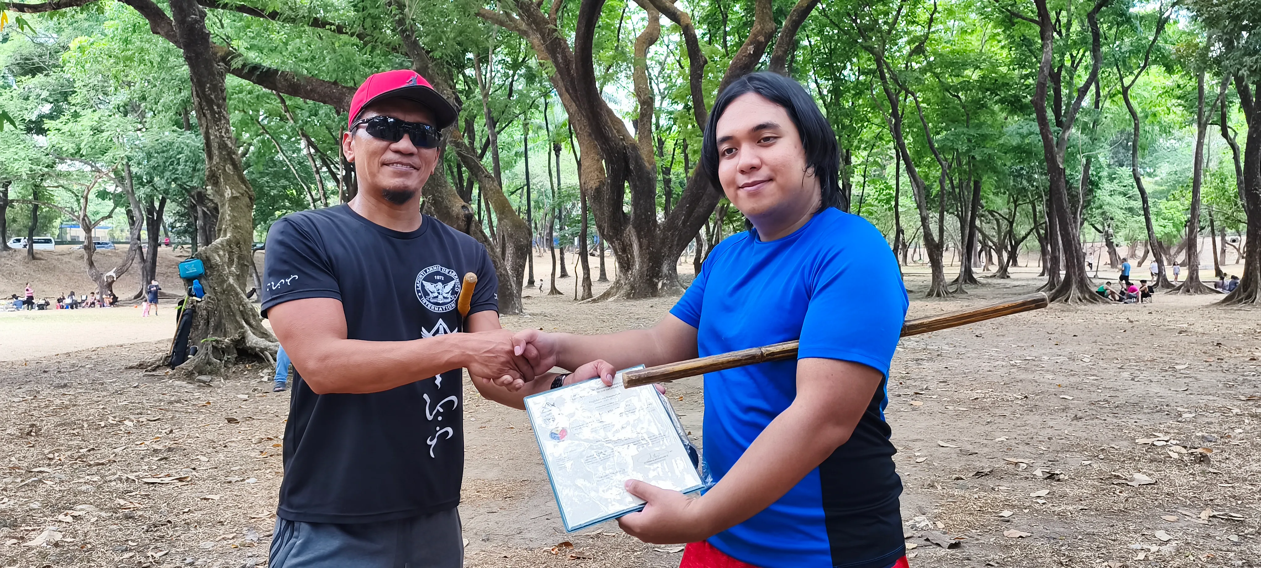 Radigan Ap-apid (R) receiving his official uniform and certificate of promotion to the rank of Luntian from Lapunti Karilyon Chief Instructor, Senior Master Buboy Ador.